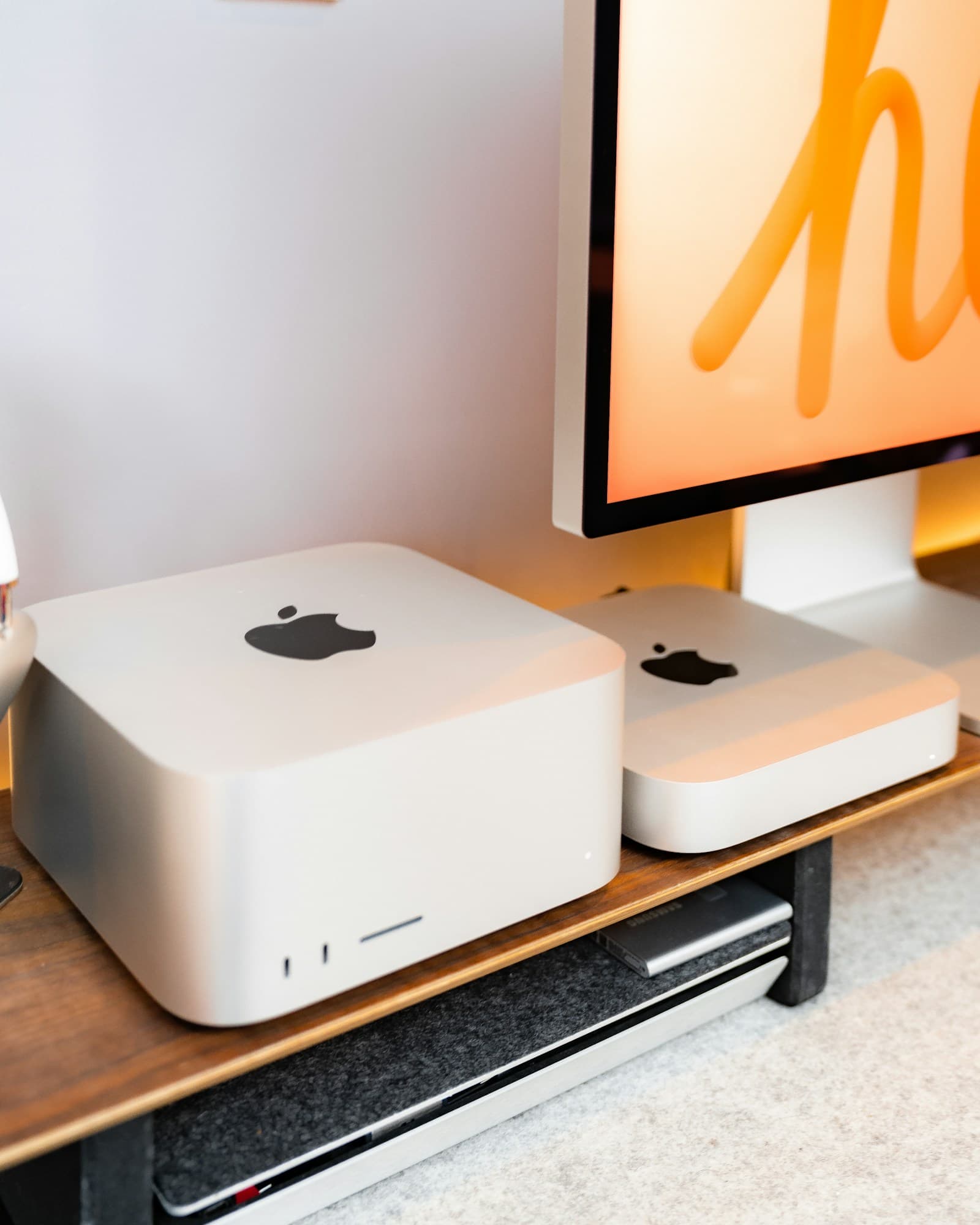 Two compact desktop computers on a wooden desk, representing private compute for small business infrastructure.